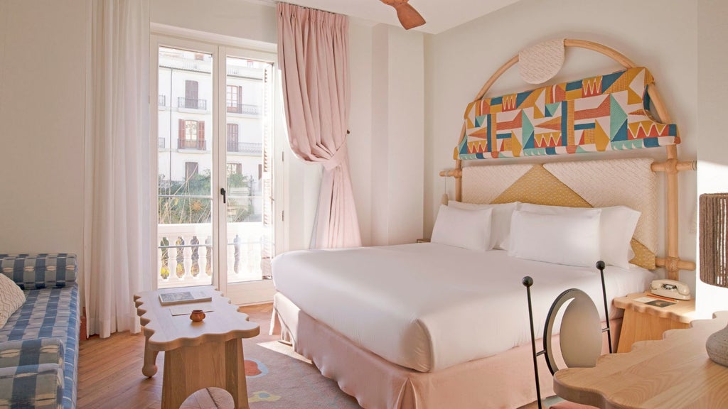 Minimalist white bedroom with mid-century modern design, large window overlooking Eivissa's historic architecture, elegant neutral color palette with sunlight streaming in