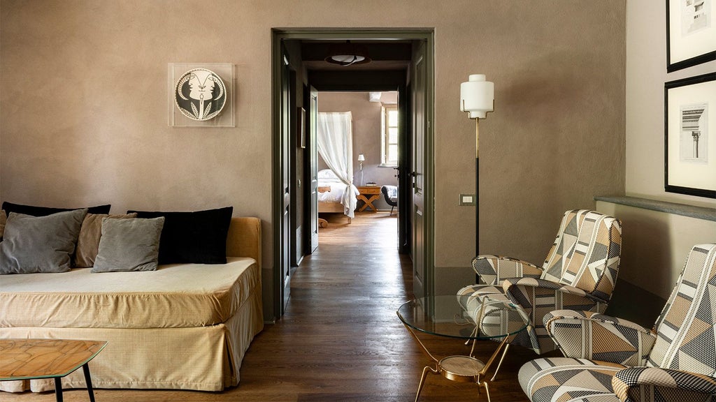 Elegant Tuscan-style hotel room with soft white linens, rustic wood furniture, and large windows overlooking serene Italian countryside landscape