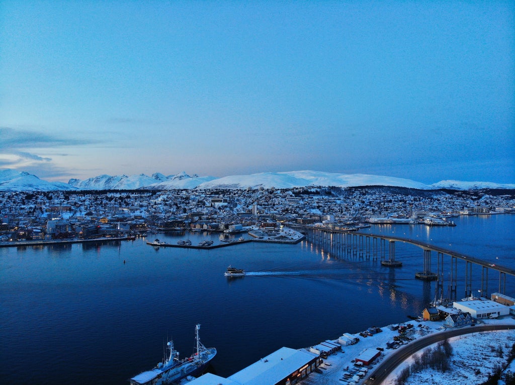 Scenic winter landscape of Tromsø Island, Norway, with snow-covered mountains, luxurious Arctic tour, featuring pristine wilderness and Northern Lights potential