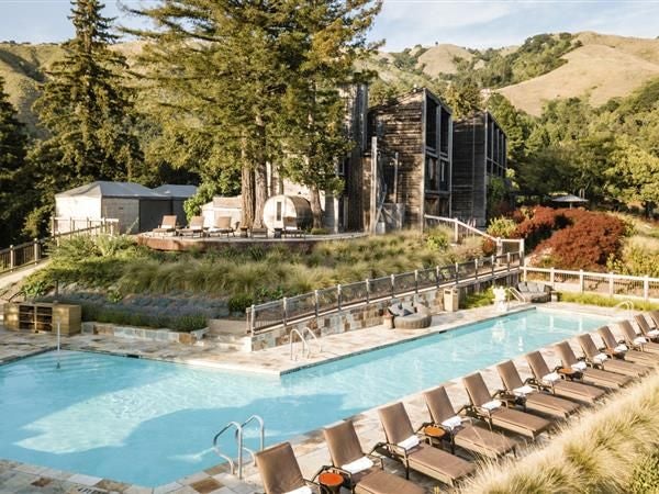 Luxurious redwood-framed eco-resort nestled in Big Sur's lush landscape, featuring rustic-modern architecture with panoramic views of California coastal wilderness