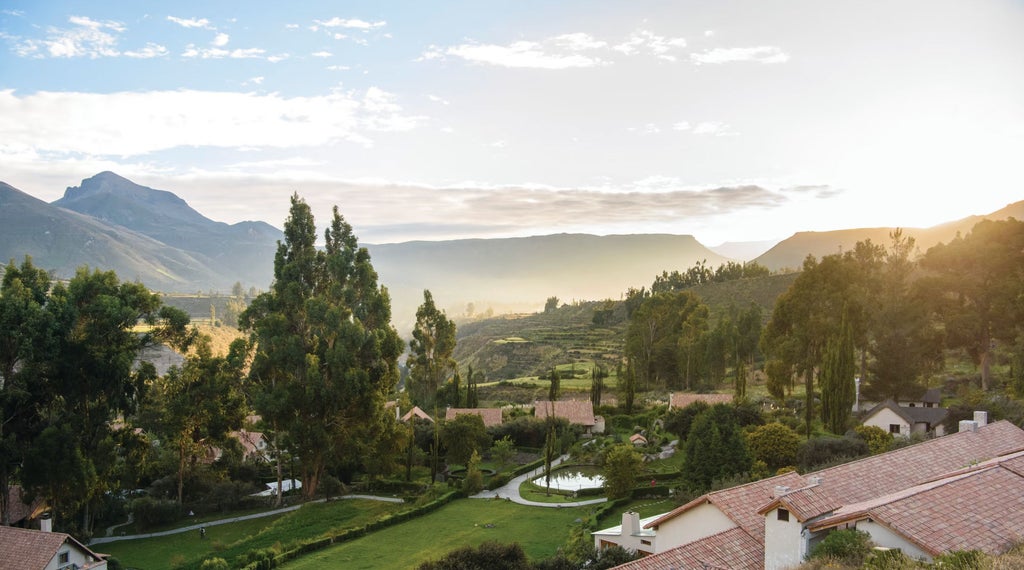 Elegant mountain resort with private stone casitas nestled in Sacred Valley, featuring infinity pool overlooking Andean peaks at sunset