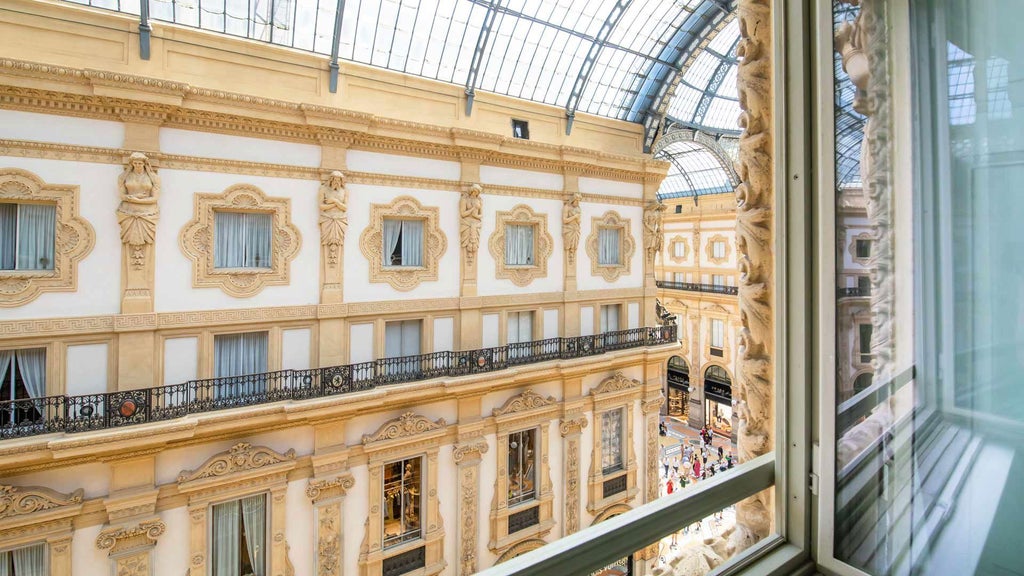 Modern Italian luxury hotel room with artistic gallery-style decor, elegant white furnishings, and expansive Milan cityscape visible through large windows