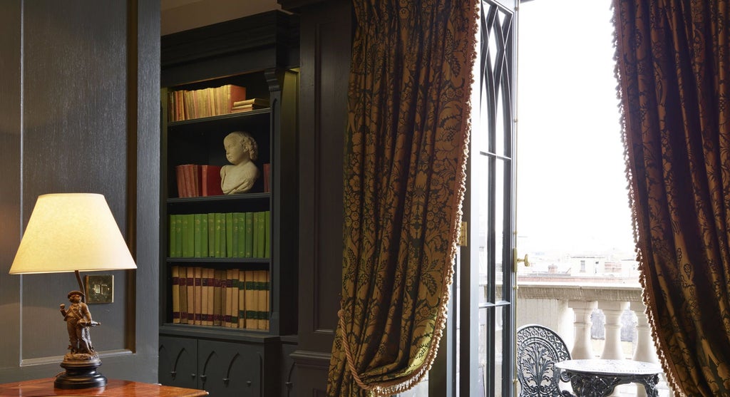 Opulent boutique hotel room with rich emerald green walls, vintage four-poster bed, and ornate period furnishings in a historic United Kingdom setting