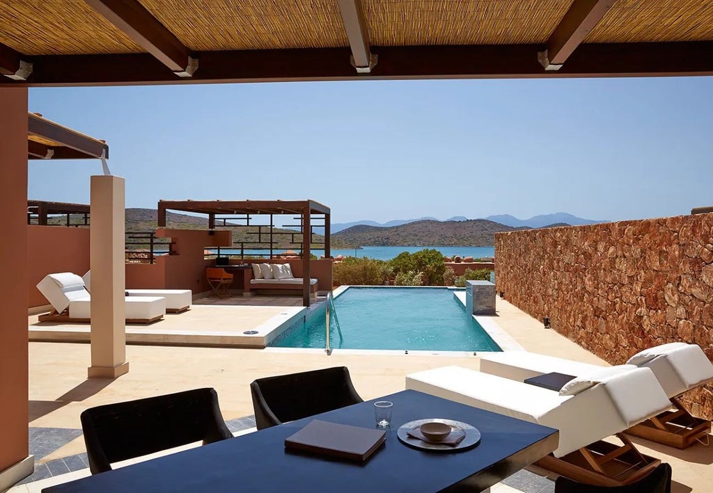 Luxurious seaside resort with white domed architecture, azure Aegean waters, and private infinity pools overlooking scenic Cretan landscape at Domes of Elounda