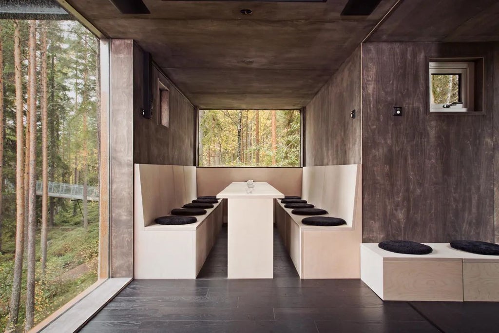 Modern geometric room suspended in forest canopy with sleek metallic exterior, large windows reflecting surrounding pine trees at Nordic wilderness retreat