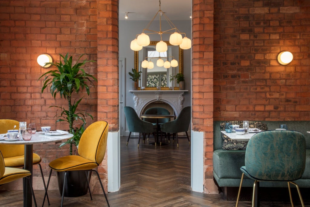 Elegant Georgian-era boutique hotel with red brick facade, ornate white trim windows, and classic black iron railings in Dublin