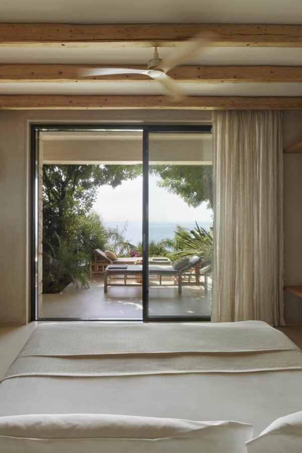 Minimalist luxury suite with wooden accents, crisp white linens, expansive sea view, and modern Greek-inspired design in F Zeen Kefalonia retreat