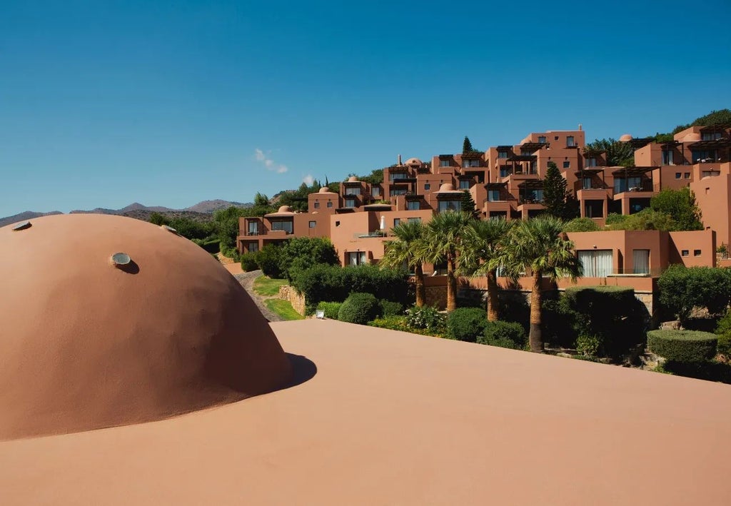 Luxurious white domed suites overlooking azure Aegean waters, with private pools and elegant Mediterranean architecture at Scenset Domes of Elounda, Crete.