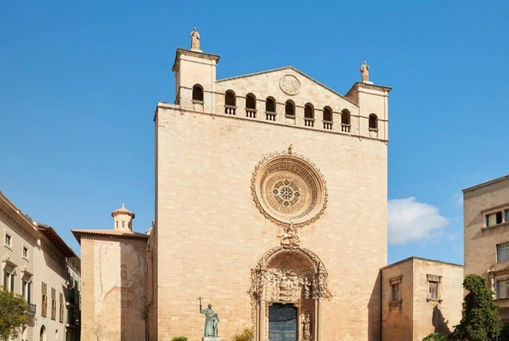 Elegant neoclassical boutique hotel in Palma de Mallorca, featuring stone facade, warm lighting, and luxurious architectural details at dusk