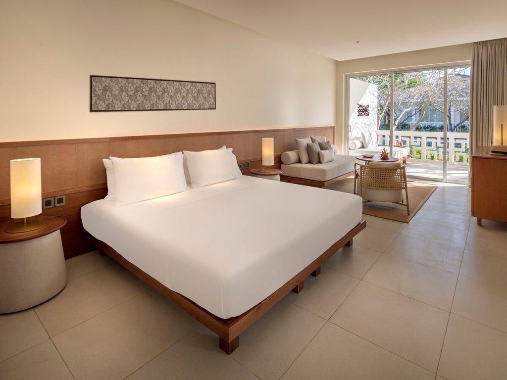 Luxurious deluxe suite at Azerai Ke Ga Bay with panoramic pool view, featuring modern Vietnamese design, elegant furnishings, and expansive natural lighting