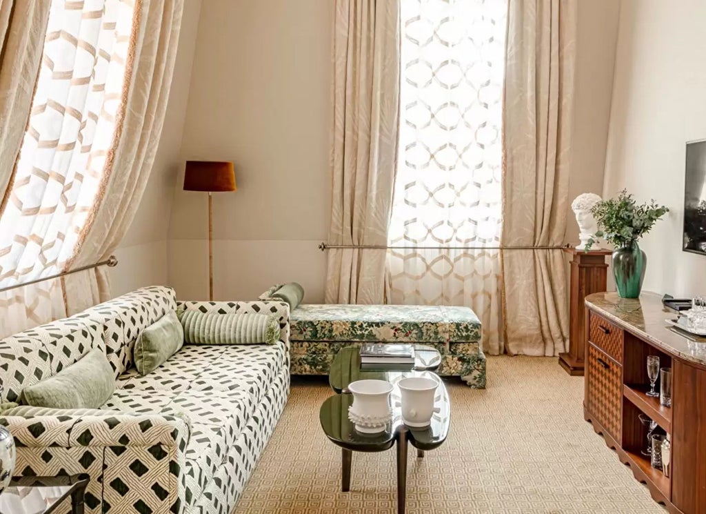 Opulent Parisian junior suite with red and gold decor, elegant four-poster bed, antique furnishings and floor-to-ceiling windows