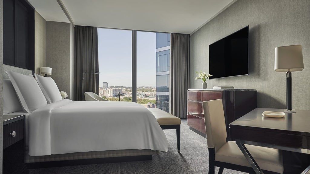 Luxurious Cambridge Suite at Four Seasons Hotel, featuring elegant king bed, plush furnishings, city view windows, and sophisticated neutral color palette