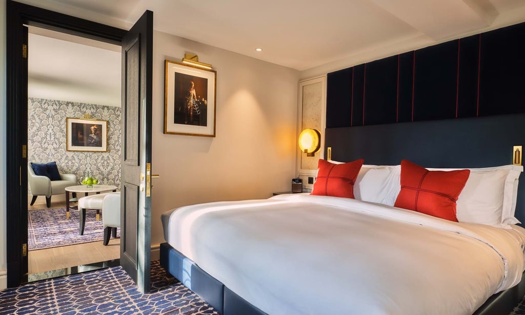 Elegant loft suite with contemporary design, featuring plush king bed, floor-to-ceiling windows, and sophisticated neutral color palette at luxury UK hotel