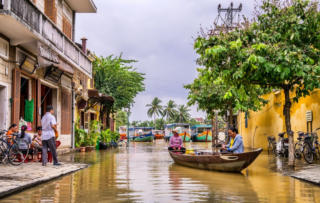 Vibrant lanterns illuminating narrow streets, traditional wooden shophouses, and local artisans crafting silk in a tranquil twilight scene of Hoi An's historic quarter.