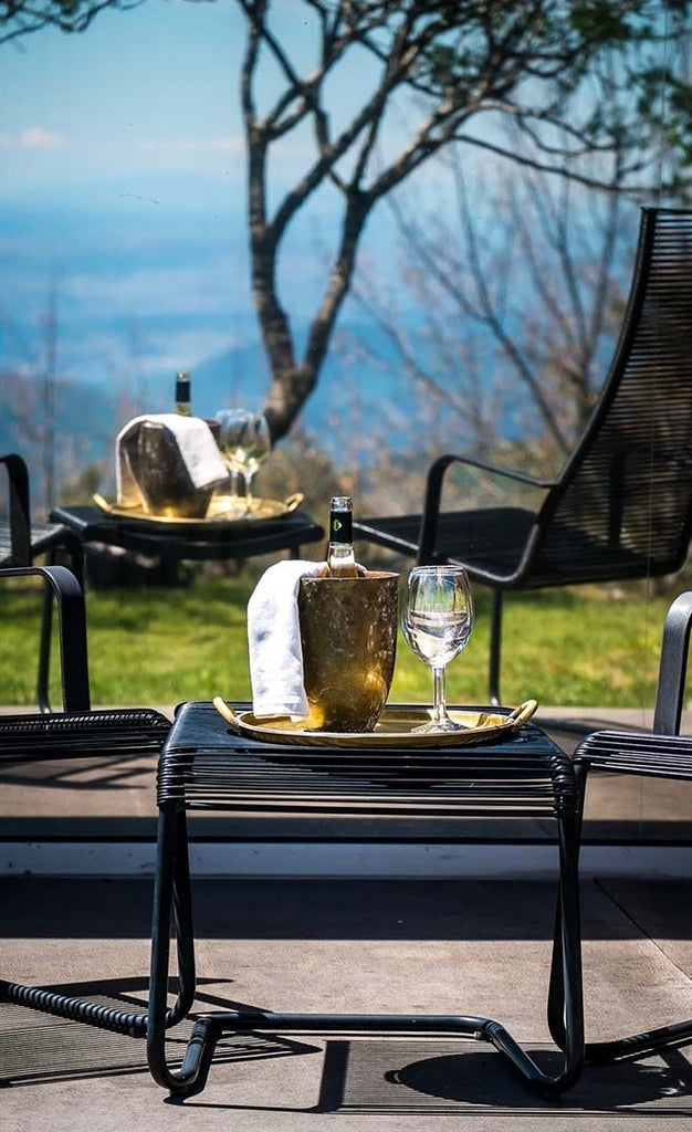 Luxurious mountain retreat nestled in Portuguese Serra da Estrela, featuring modern design with warm wood tones and panoramic alpine landscape views