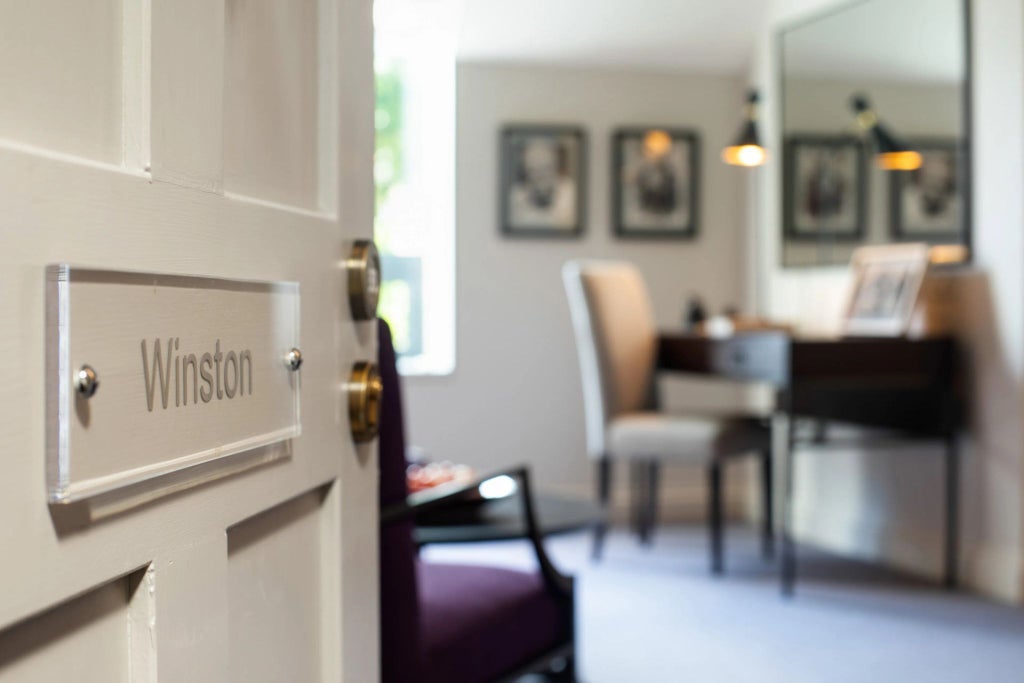 Elegant suite at historic hotel in United Kingdom, featuring sophisticated decor, plush bedding, and refined British charm in classic neutral tones