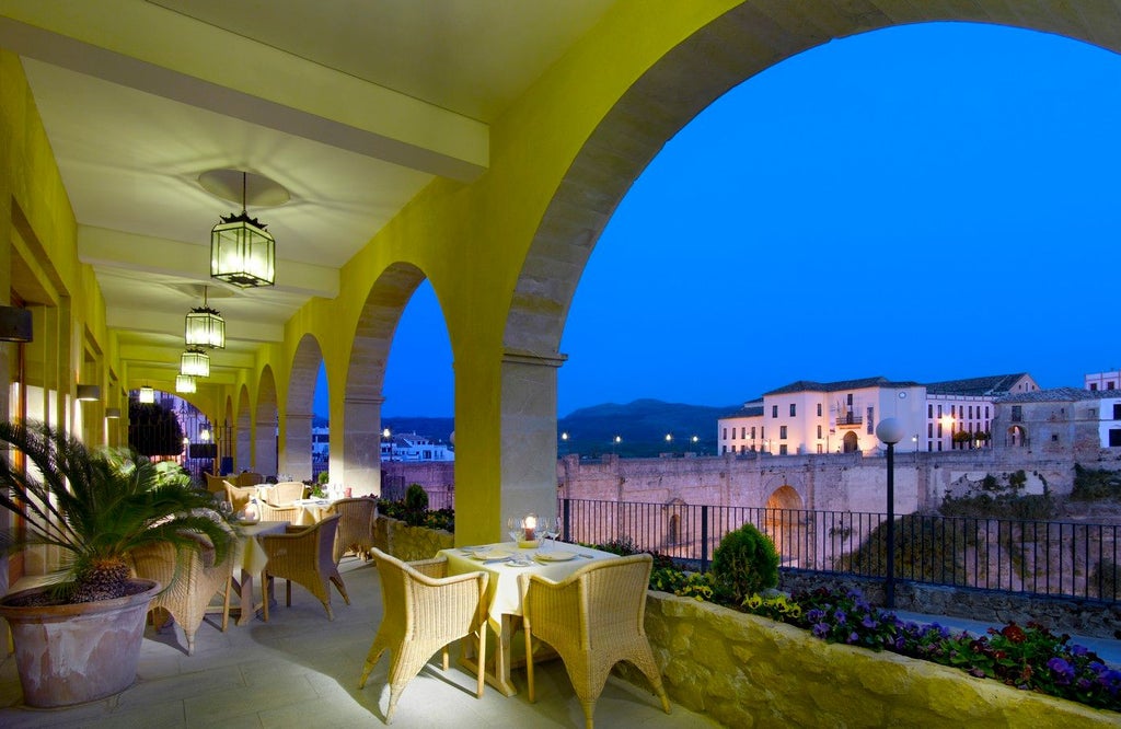 Elegant Spanish colonial-style hotel with whitewashed walls, terracotta roof tiles, ornate balconies and lush Mediterranean gardens