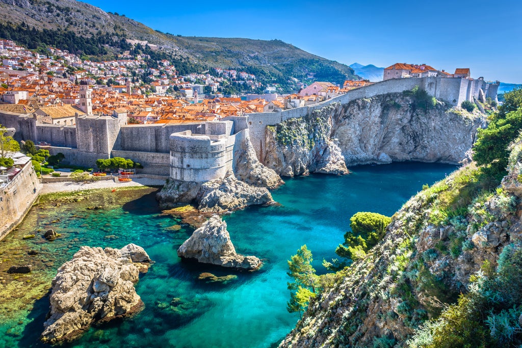 Ancient stone streets and medieval walls of Dubrovnik's Old Town, with the Adriatic Sea and terracotta rooftops in golden sunlight