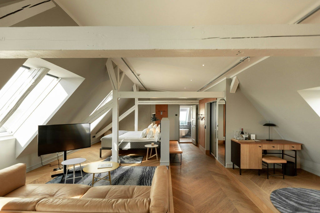 Spacious penthouse suite with minimalist Danish design, featuring floor-to-ceiling windows, modern furnishings, and panoramic city views of Copenhagen's skyline