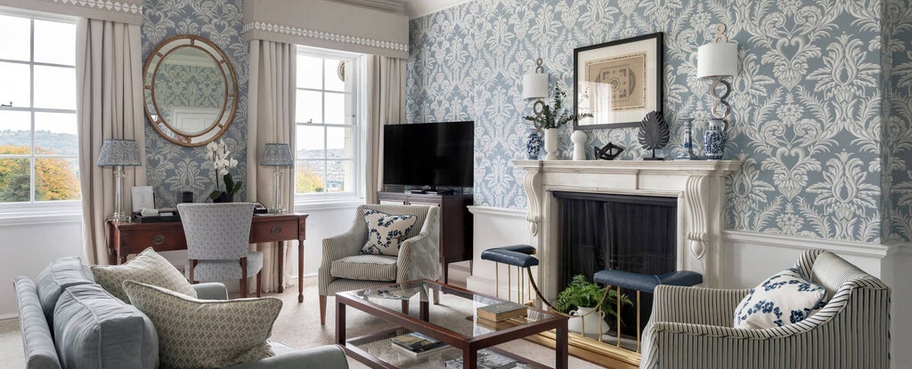 Elegant cream-colored deluxe suite at The Royal Crescent Hotel & Spa with plush king bed, period furnishings, and soft natural lighting in Bath, United Kingdom