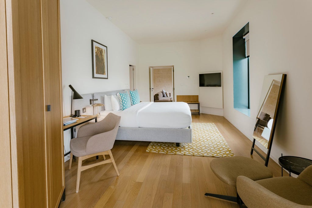 Elegant corner suite at Cugó Gran Macina with expansive harbour view, featuring contemporary design, plush furnishings, and sweeping maritime panorama of Malta's coastline