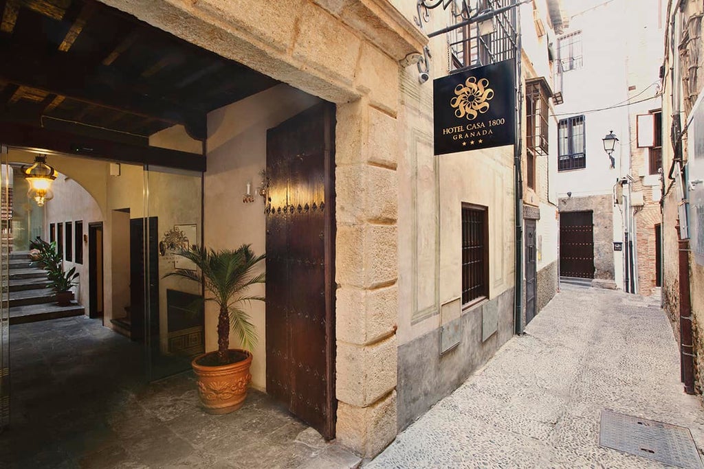 Elegant boutique hotel in Granada with ornate Moorish-style courtyard, crystal chandelier, marble floors and wrought-iron balustrades