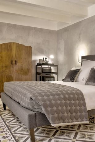 Elegant boutique hotel suite in Maltese historic building, featuring sophisticated modern design with vintage architectural details and luxurious minimalist decor