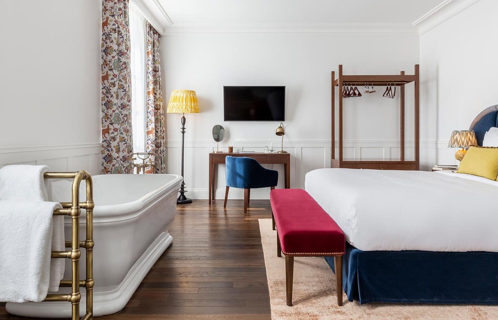 Elegant French hotel room at La Maison d'Estournel, featuring plush white bedding, warm wood accents, and soft ambient lighting in soft neutral tones