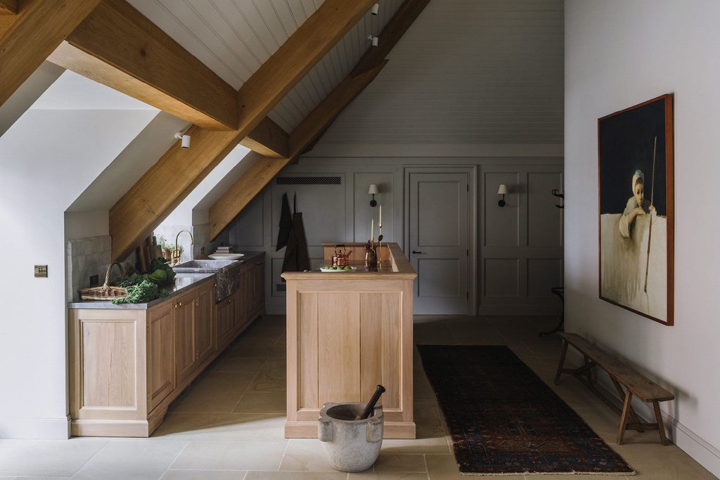 Elegant long room at Heckfield Place hotel, featuring soft natural light, refined wooden furniture, and understated British countryside sophistication