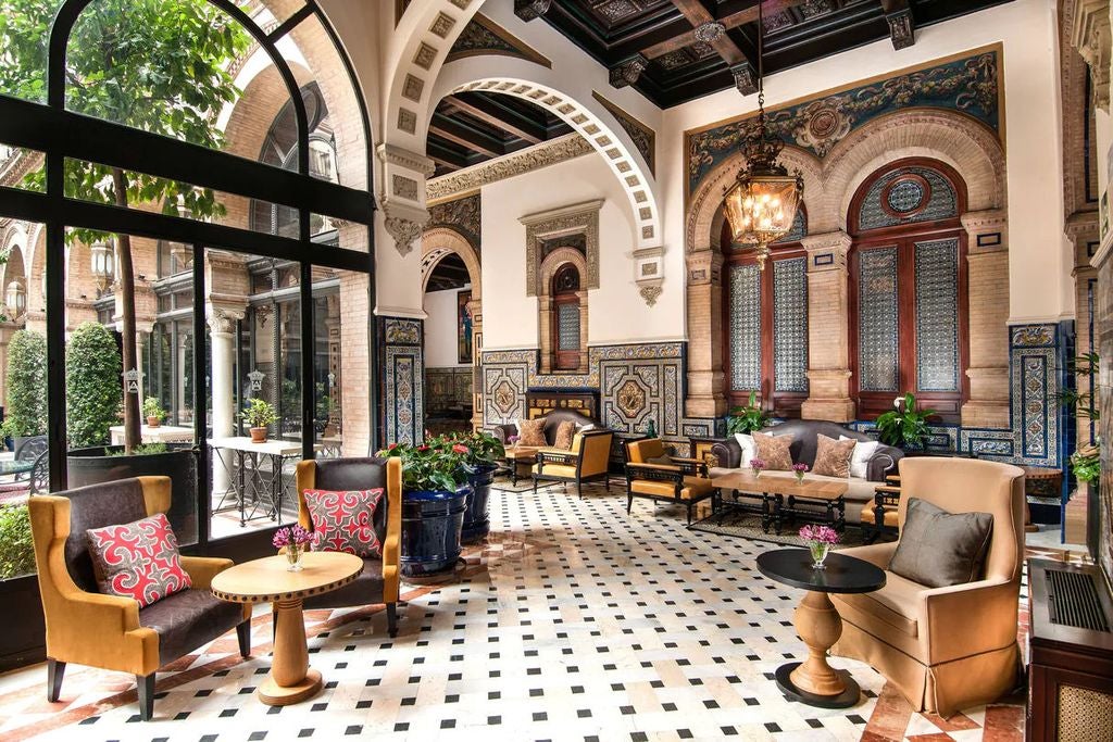 Historic Hotel Alfonso XIII in Seville features ornate Moorish architecture with arched windows, marble columns and a grand entrance courtyard