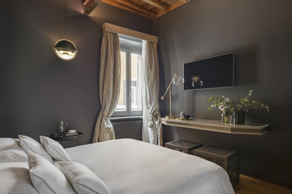 Elegant Italian boutique hotel entrance with ornate golden details, marble flooring and classic Roman-style décor and lighting