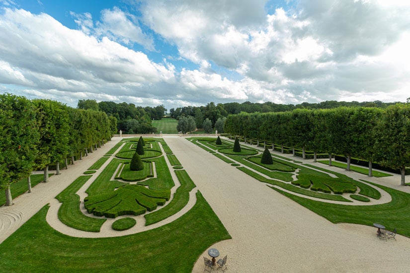 Elegant Superior King Room with ornate 18th-century French decor, crystal chandelier, garden views, and antique furnishings at Château du Grand-Lucé