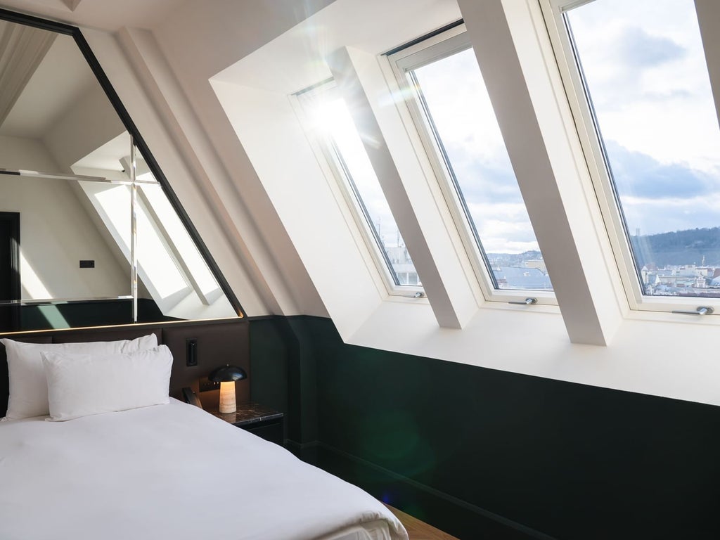 Luxurious hotel suite at Almanac X with elegant modern decor, expansive Prague Castle panorama through floor-to-ceiling windows, sophisticated Czech design elements