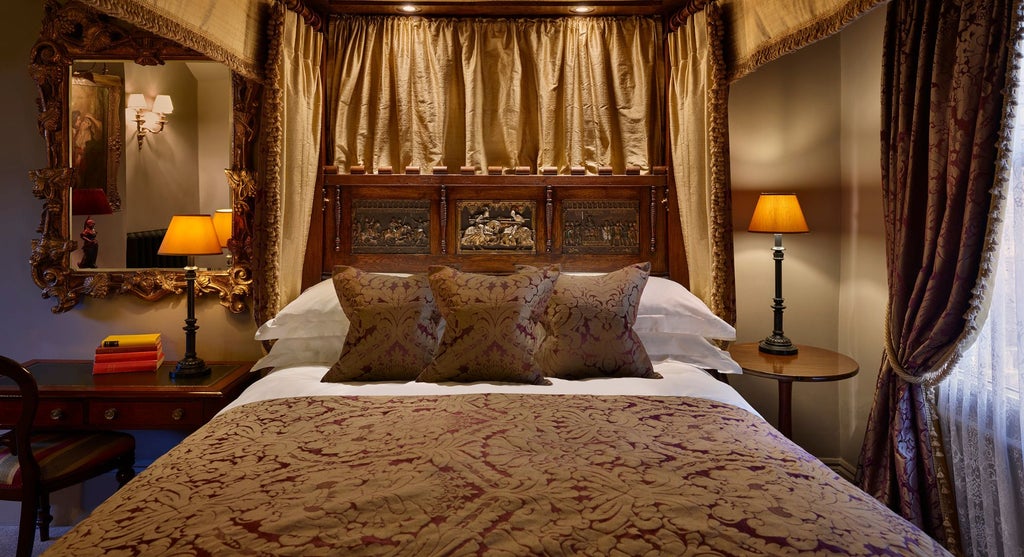 Elegant four-poster bed in a luxurious Superior room at The Rookery hotel, featuring rich wooden furnishings and sophisticated British design accents