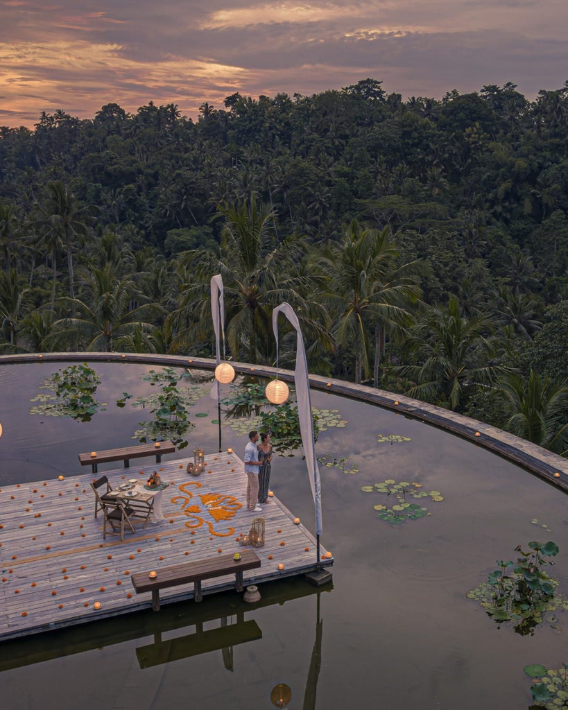 Luxurious sunset rooftop dining in Bali, with elegant table setting, tropical greenery, and panoramic views of Indonesian landscape