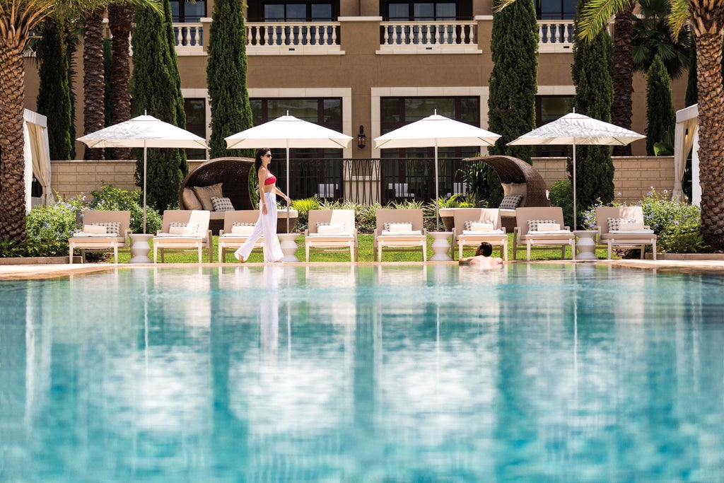 Opulent Four Seasons Orlando resort with lakeside palm trees, reflecting pool, Mediterranean-style architecture at golden sunset hour