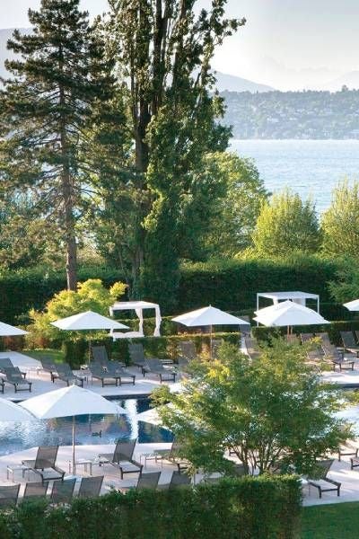 Elegant executive hotel room with lake view, plush white bedding, contemporary Swiss design, and minimalist luxury furniture at La Réserve Genève Hotel and Spa