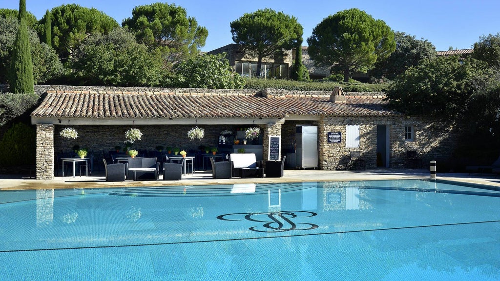 Elegant stone villa with modern spa complex nestled in French countryside, featuring lush gardens and infinity pool overlooking Provence