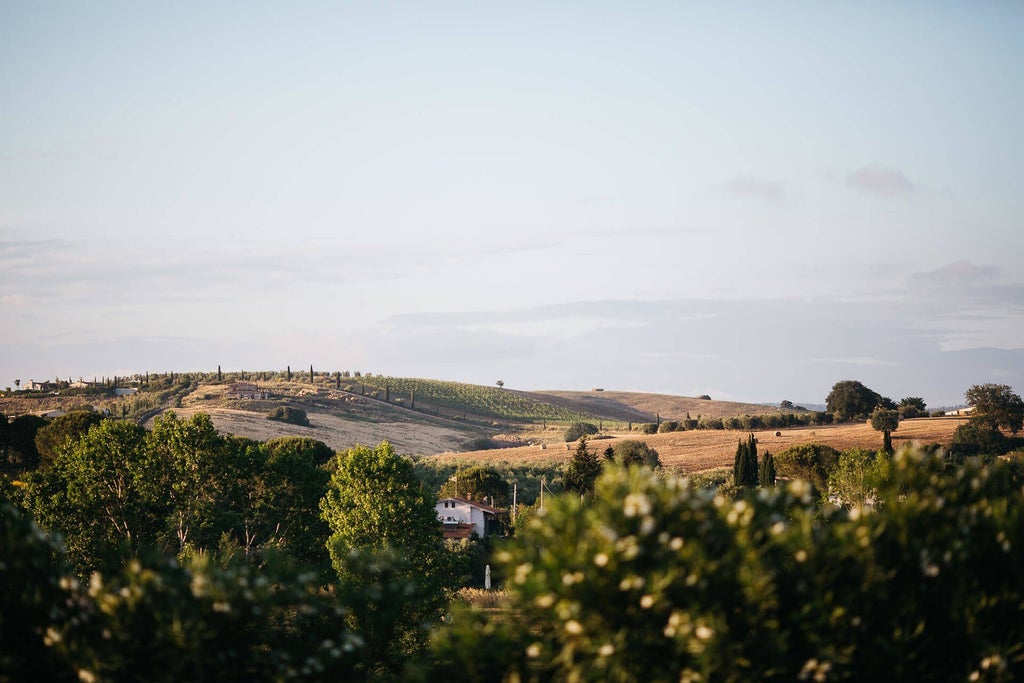 Rustic Tuscan boutique hotel with stone facade, terracotta roof, lush gardens, and elegant outdoor seating area surrounded by cypress trees and rolling hills