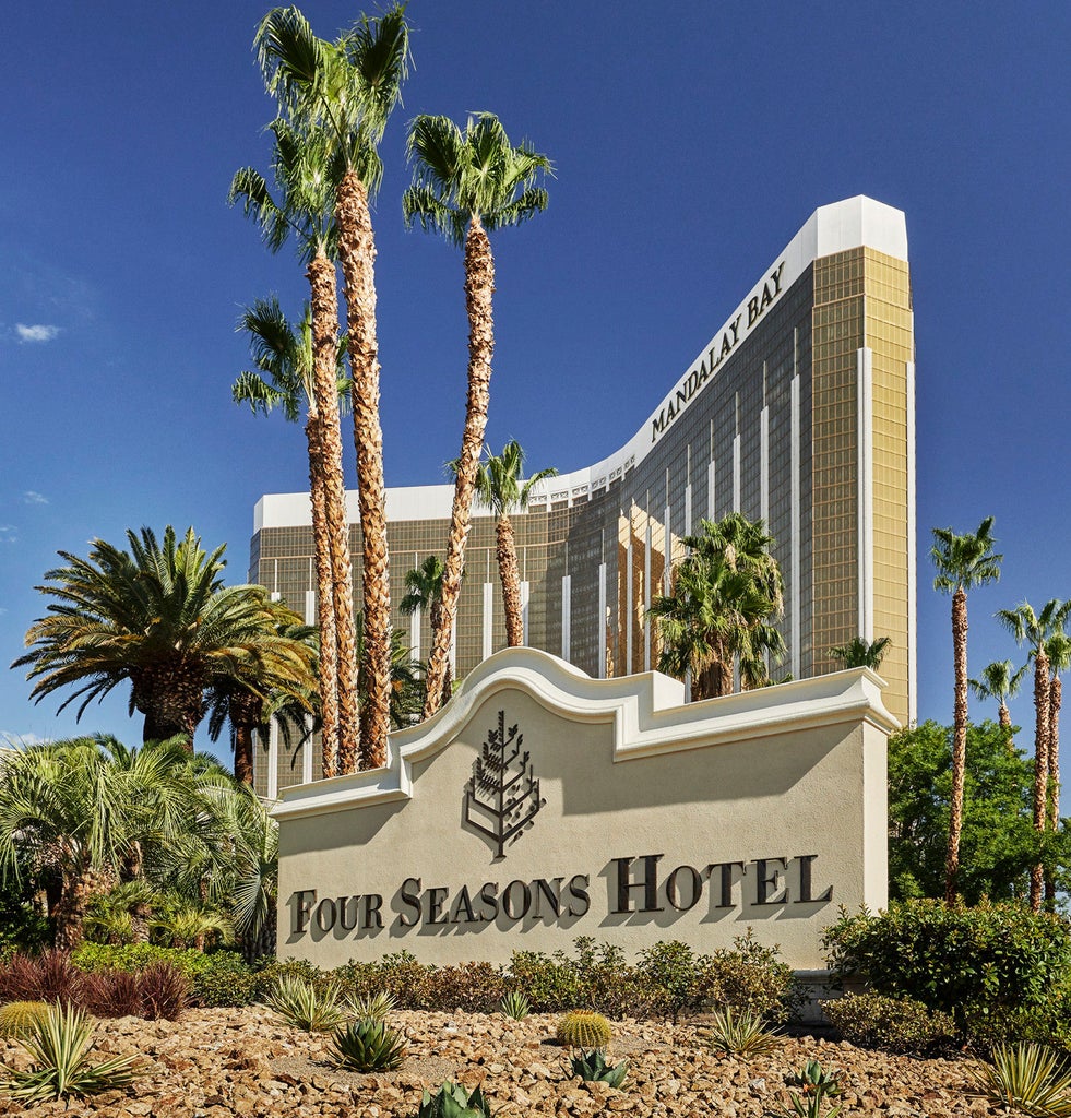 Luxurious Four Seasons Las Vegas exterior at dusk with illuminated facade, palm trees, and grand entrance featuring modern architecture