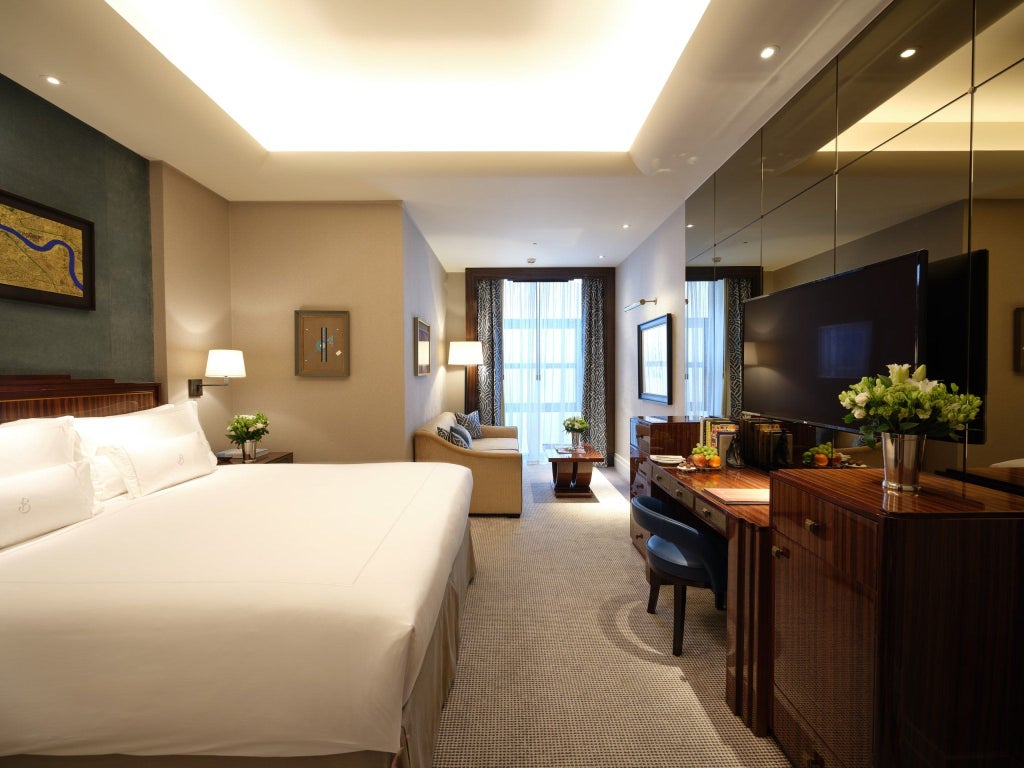 Elegant studio room at The Beaumont Mayfair, featuring plush king bed, contemporary artwork, soft neutral tones, and luxurious marble-detailed bathroom