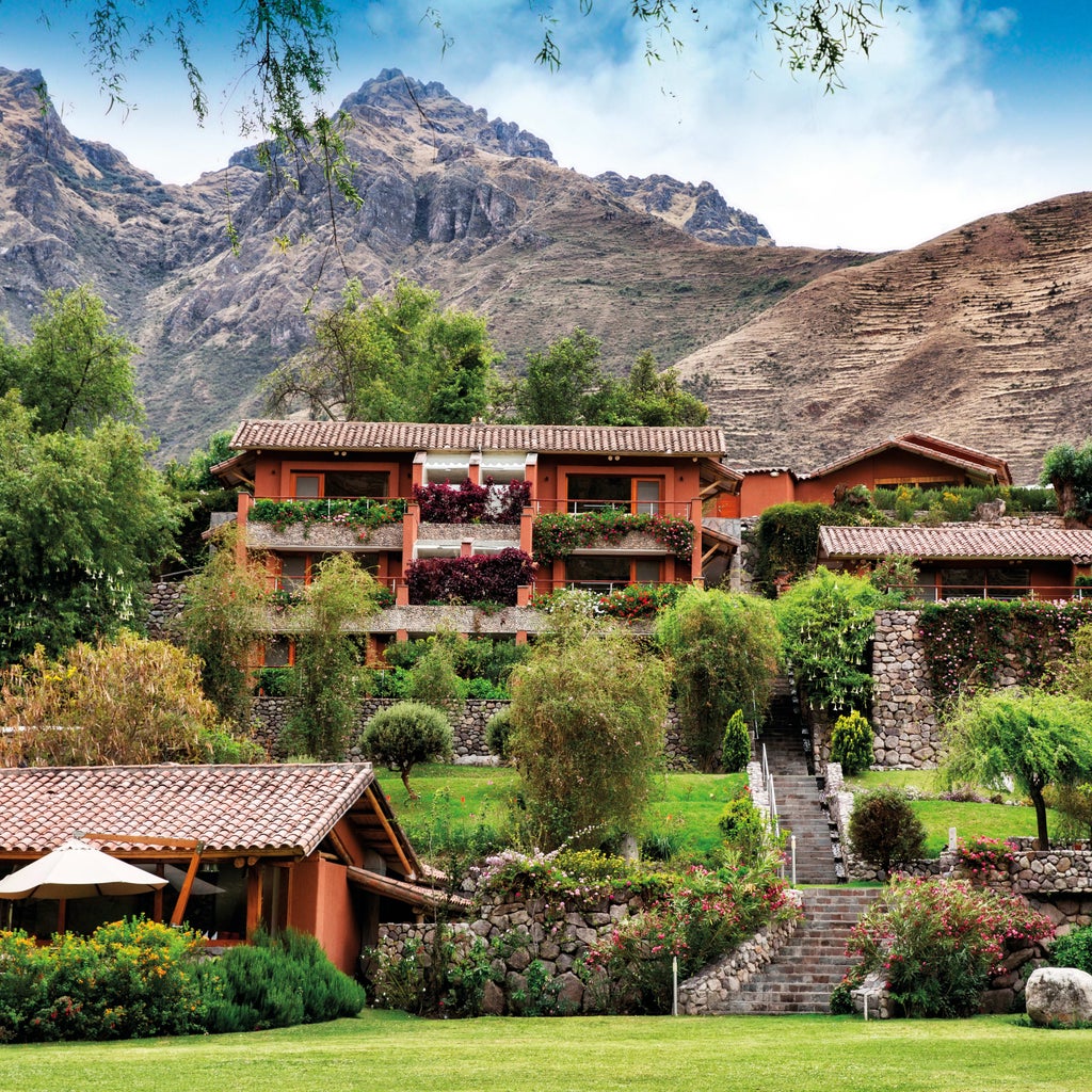 Upscale hotel nestled in Peru's Sacred Valley with stone pathways, lush gardens, and luxury villas overlooking the Urubamba River