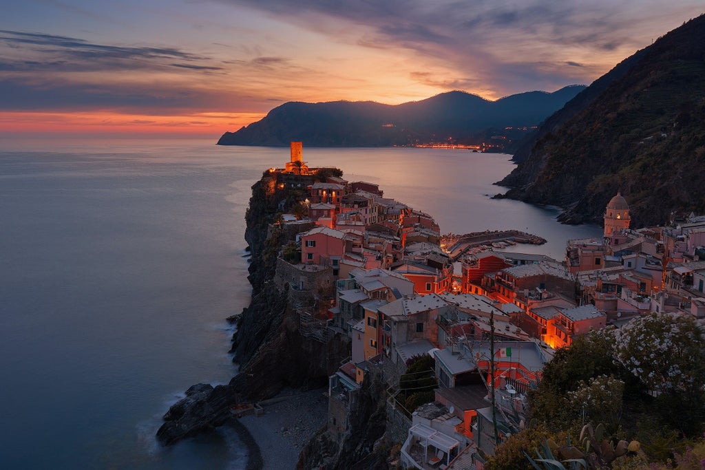 Five colorful cliffside villages of Cinque Terre along Italian Riviera coastline, with vibrant buildings nestled against rugged cliffs