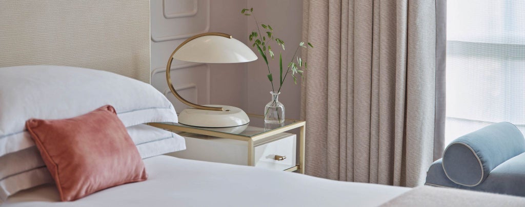 Luxurious superior hotel room at scenset with plush white bedding, modern design, and elegant neutral tones, showcasing sophisticated urban accommodation.