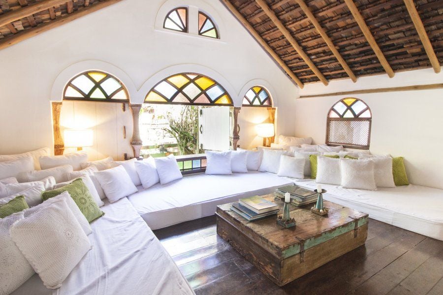 Luxurious Brazilian hotel room with traditional wooden furnishings, vibrant textiles, and soft ambient lighting, showcasing rustic elegance at UXUA Casa Hotel and Spa