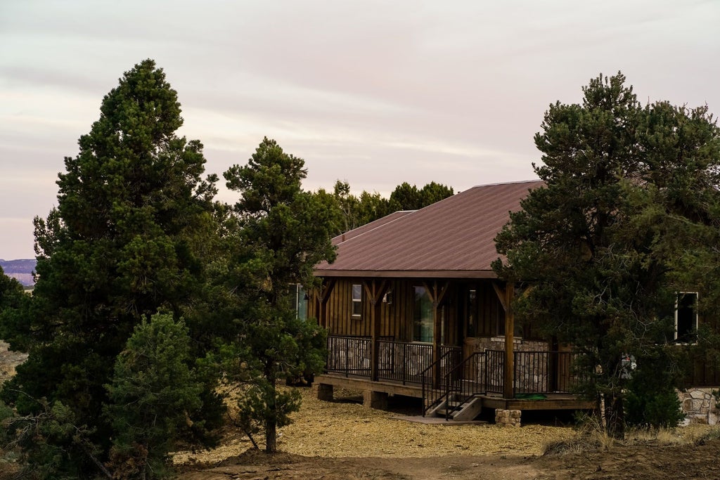 Spacious rustic lodge room with wooden furnishings, plush bedding, and panoramic mountain views at scenset Mountain Ranch in the western United States.