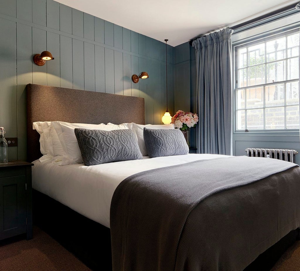 Elegant cozy hotel room with soft neutral tones, plush bedding, warm lighting, and sophisticated minimalist design in United Kingdom accommodation