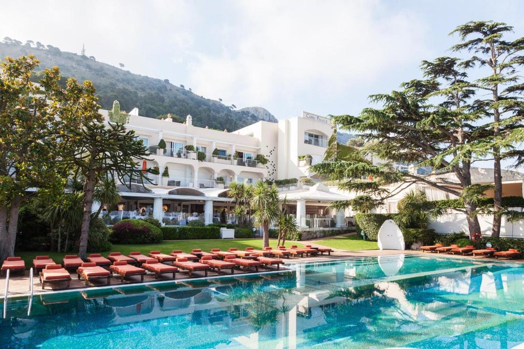 Elegant white Mediterranean hotel with cascading terraces, infinity pool overlooking the sea, and lush gardens in Anacapri, Italy