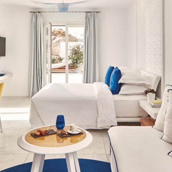 Luxurious white-washed suite with panoramic Aegean Sea view, minimalist design, private infinity pool, and elegant Mykonos-inspired Mediterranean decor