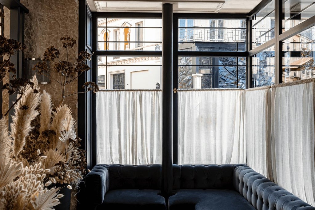 Elegant boutique hotel facade in Paris's 9th arrondissement, featuring Art Deco-inspired architecture with soft pastel colors and ornate balconies